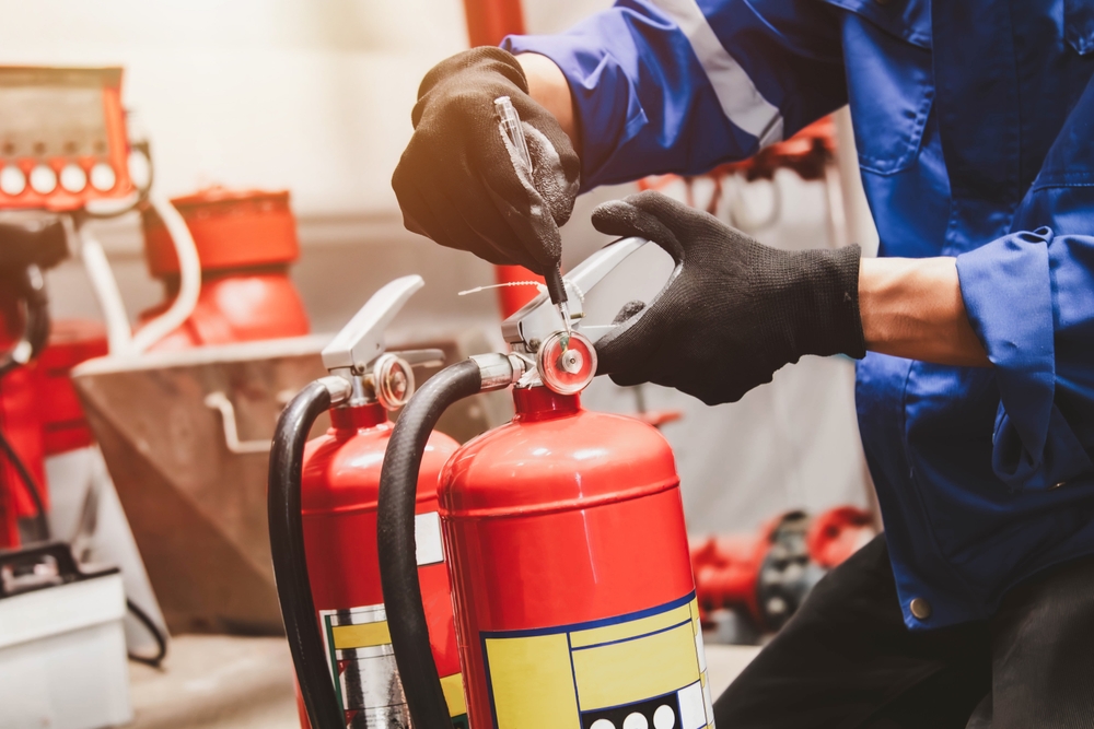 Worker checking a fire extinguisher