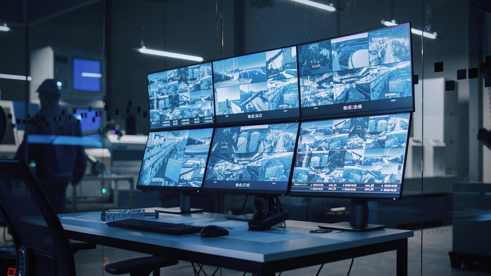 Bank of CCTV monitors in a modern factory security control room