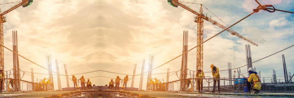 Construction workers on a building site at sunrise