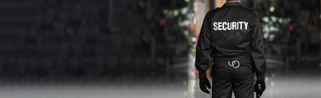 Security officer in a black uniform on patrol at night