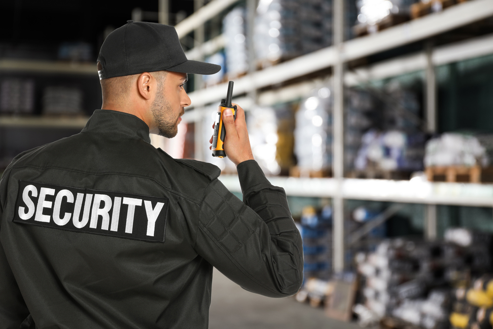 Security officer using a radio in a warehouse