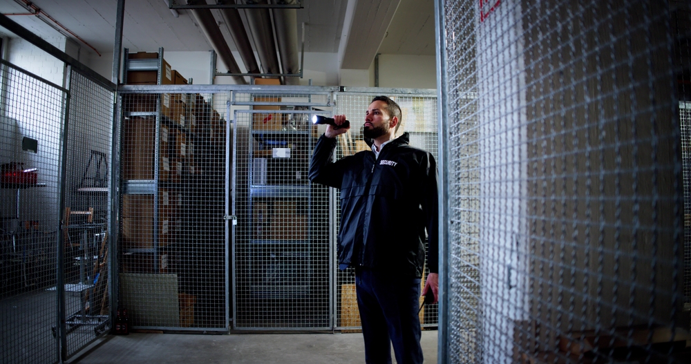 Security officer patrolling a warehouse storage area