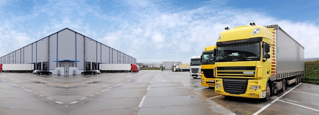 HGVs and trailers parked in the yard of a UK distribution warehouse
