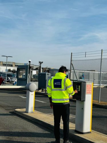 Security officer operating a vehicle barrier at a gatehouse entrance