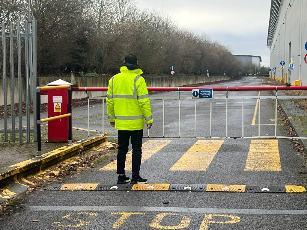 SIA-licensed security officer at a vehicle barrier on a UK industrial site